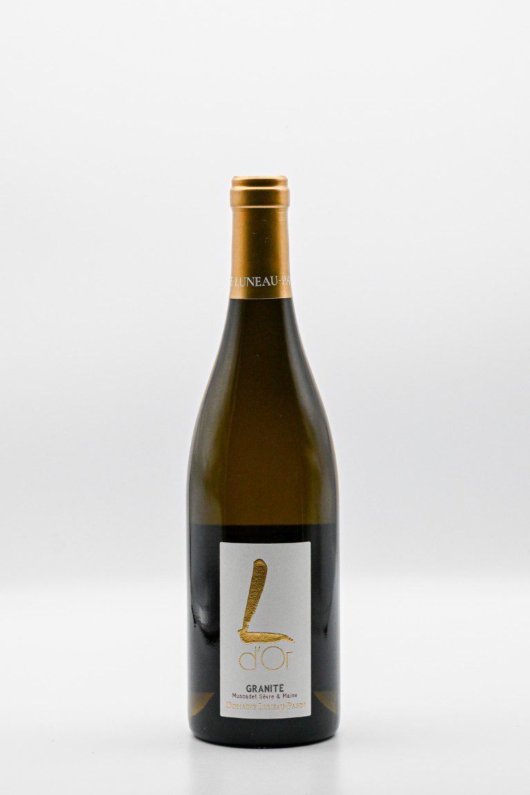 Fles witte wijn met gouden etiket op een tafel